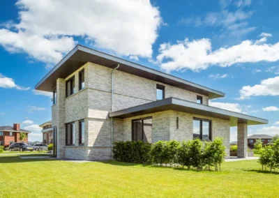 gevel van licht metselwerk met donkere aluminium kozijnen